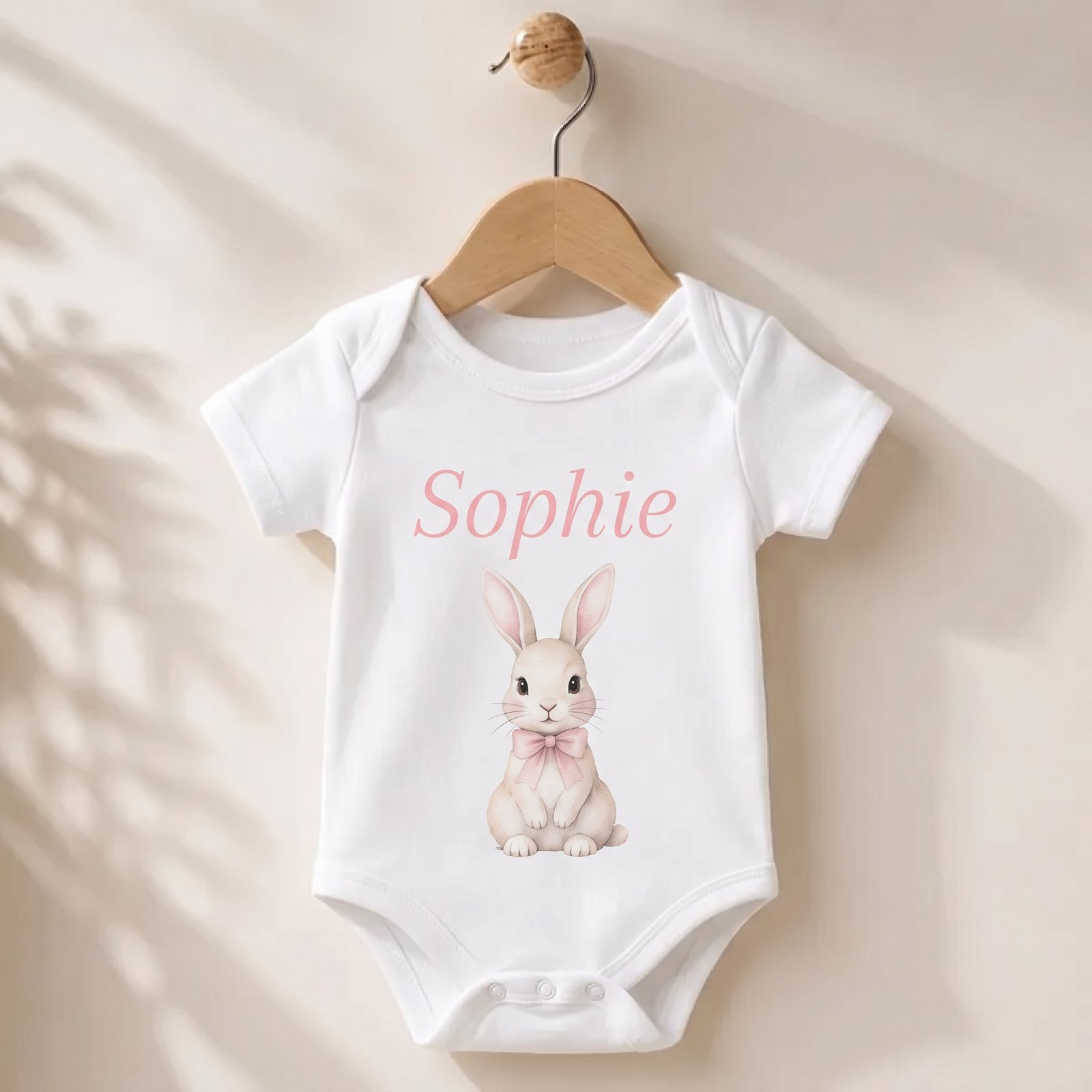 Wit baby rompertje met de naam Noah bedrukt in paars lettertype, newborn kraamcadeau